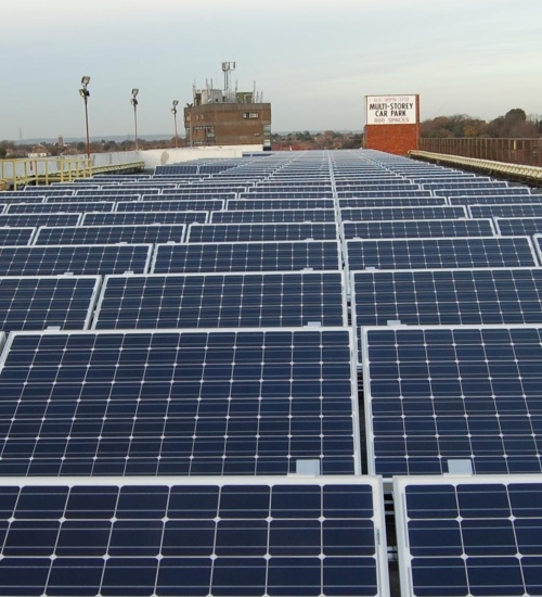 Rows of solar photovoltaic panels installed on the roof of a multi-storey car park