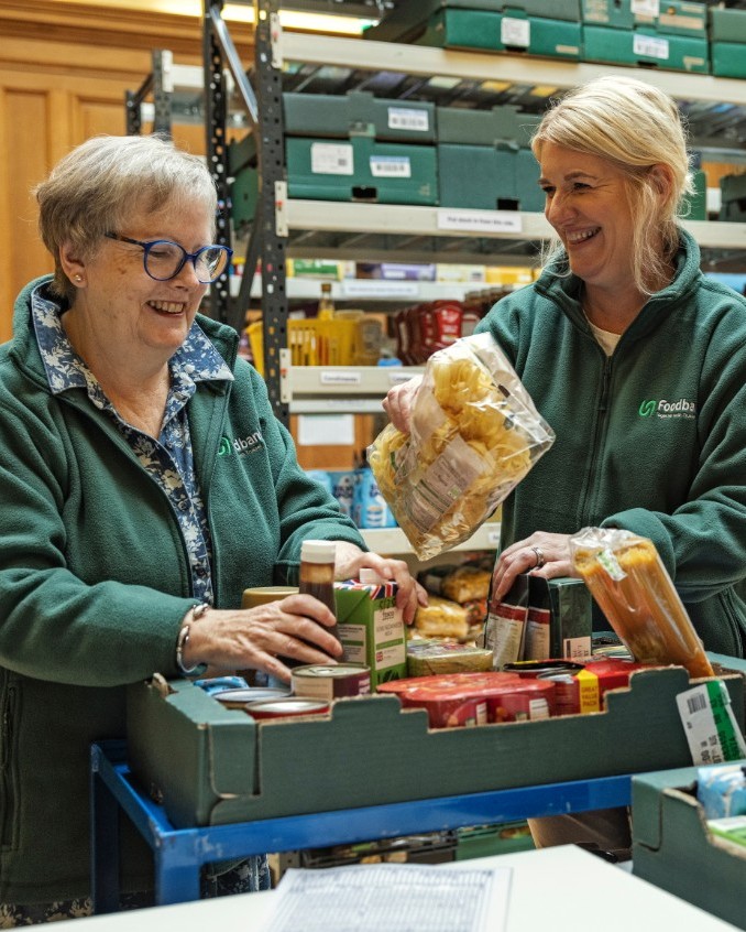 Foodbank volunteers sorting donated food items in a warehouse