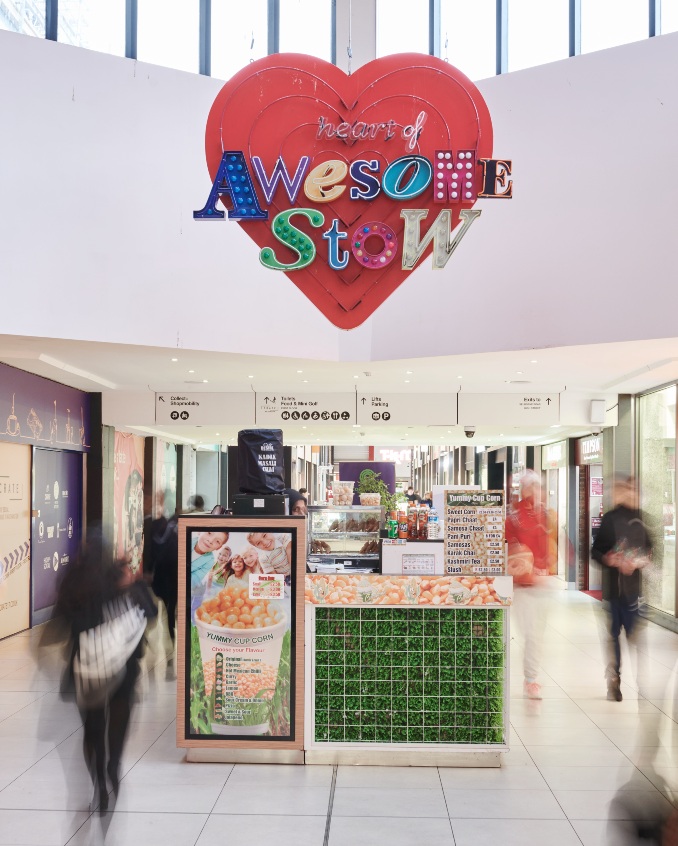 Shopping centre interior with ‘Heart of Awesome Stow’ sign and people walking through